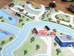 Detailansicht des Bauernhofs auf dem Fluffy Town Spielteppich mit Kühen, Schweinen und Traktor