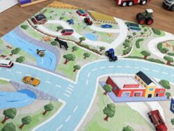 Bauernhofszene auf dem Fluffy Town Spielteppich mit Tieren, Traktor und Fluss