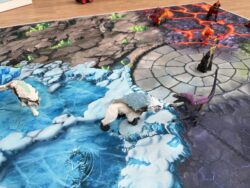 Fantasy-Spielteppich ‘Fantasy World’ mit Eiswelt und Steinwelt, gezeigt mit Spielfiguren wie Eisbär und Wolf nahe der zentralen Arena.“