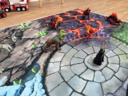 Fantasy-Spielteppich ‘Fantasy World’ mit zentraler Battle Arena und angrenzender Lavawelt, ergänzt durch verschiedene Spielfiguren.